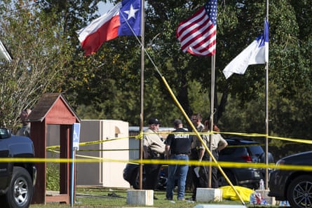 Law enforcement officials stand next to a covered body at the scene of a fatal shooting at the First Baptist church in Sutherland Springs, Texas.
