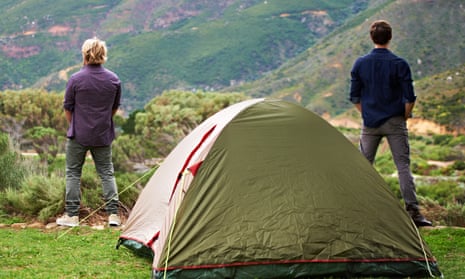 Stock photo of two men relieving themselves at a campsite with their backs to the camera