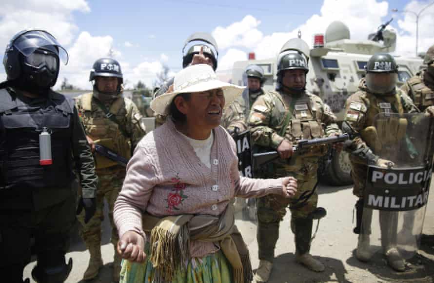 A woman protests in front of security personnel against the interim government of Jeanine Ãnez.