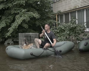 A volunteer in a rubber dinghy rescues cats in the flooded harbour district in Kherson, Ukraine, 9 June 2023
