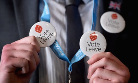 A man holds Vote Leave badges