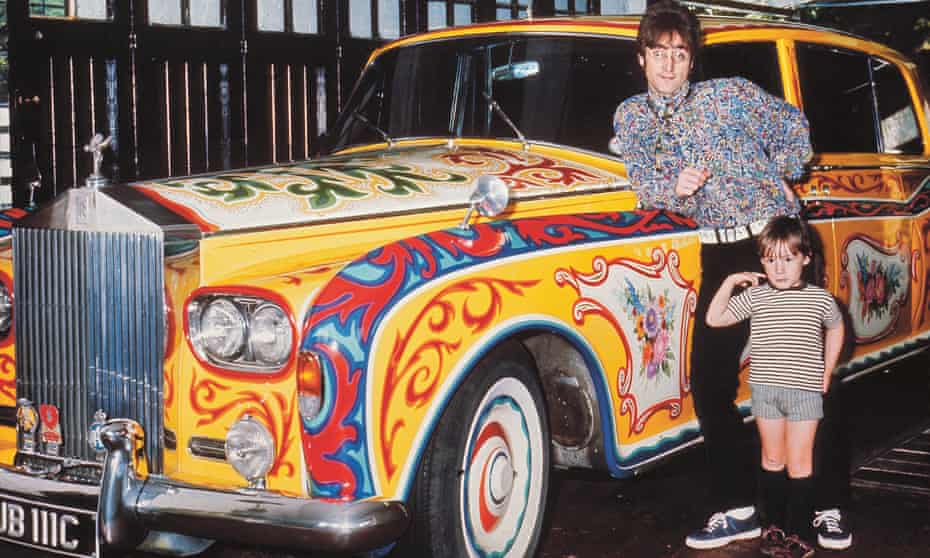John Lennon and his young son Julian posing in his house’s garage in front of his psychedelic Rolls Royce.