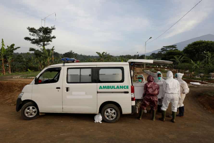 Gravediggers unload the coffin of 64-year-old Yoyoh Sa’diah who passed away due to complications related to Covid-19.