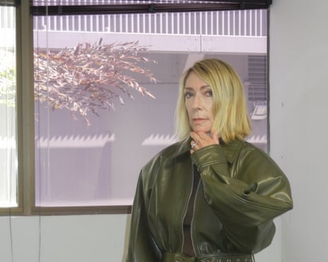 Kim Gordon in a green outfit by window