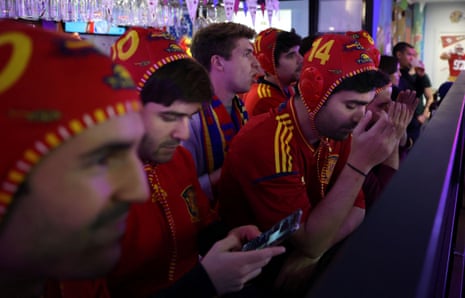 Spanish supporters react as they watch the live broadcast of the defeat to Morocco in a bar in Madrid.