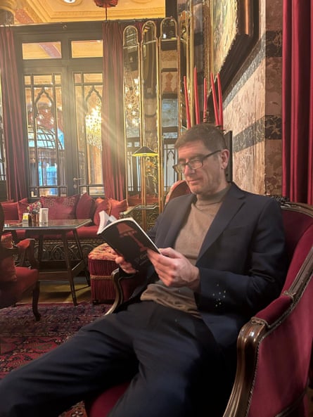 A man sitting in a hotel lounge reading a book