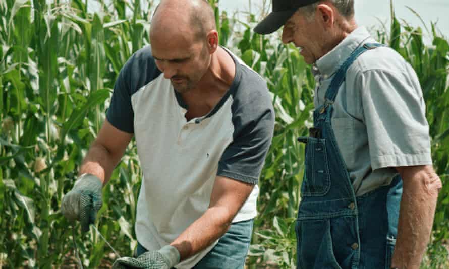 Brownie Wilson of the Kansas Geological Survey and Bill Mai measure the diminishing levels of the Ogallala Aquifer on Mai's family farm.