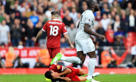Liverpool’s Dejan Lovren clutches his face after being caught by the Manchester United forward Romelu Lukaku in what was widely seen as an accident.
