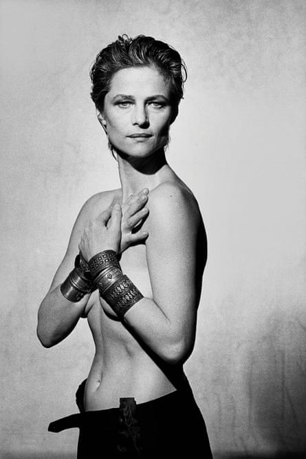 Charlotte Rampling, her arms across her naked chest, large bangles on her wrists
