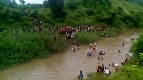 Rohingya people in Myanmar, apparently fleeing across a river with their belongings