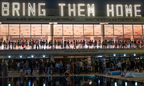 People light yahrzeit candles as a large group of people gather for a community led music circle in Tel Aviv, Israel.