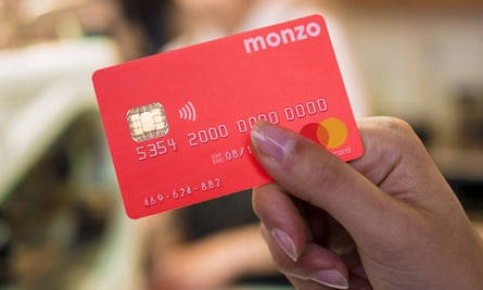 A woman's hand holding a red Monzo card