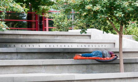 A homeless man sleeps on steps in Seattle.