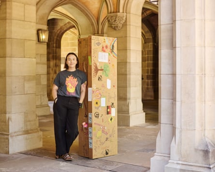 Dr Hannah Gould stands beside a cardboard coffin at the University of Melbourne