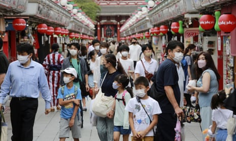 People wearing face masks to protect against the spread of the coronavirus walk Asakusa Nakamise shopping street in Tokyo, Japan