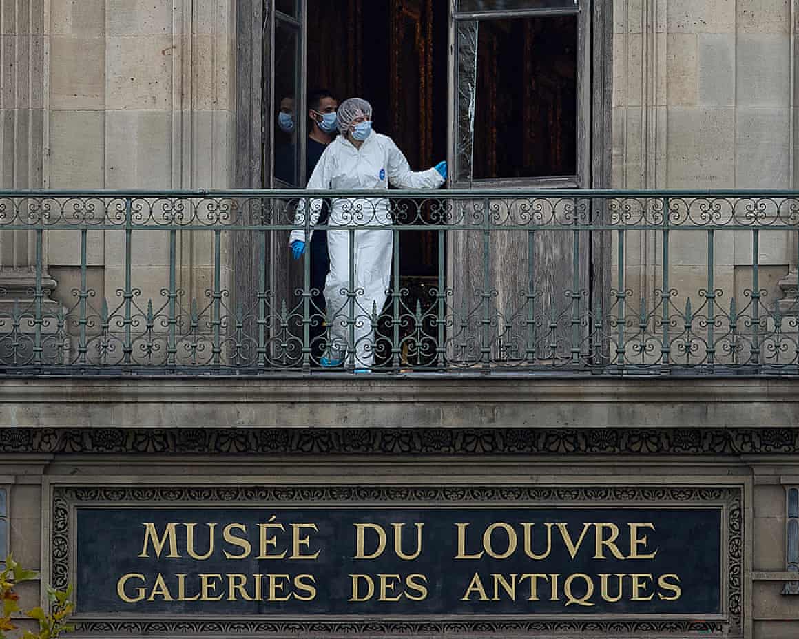 A French forensics officer examines the window and balcony of a gallery at the Louvre Museum after the robbery.