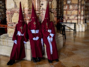 Members of Nazarenos brotherhood take a rest after participating in the traditional Lord’s Passion procession in Zipaquira, Colombia.