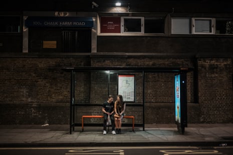 A couple at a bus stop on Chalk Farm Road in Camden