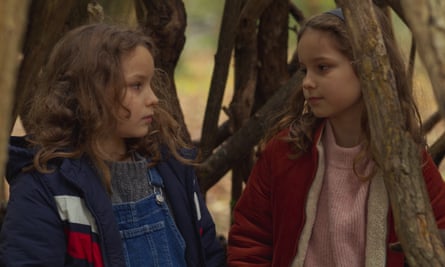 Two young girls talking in the woods