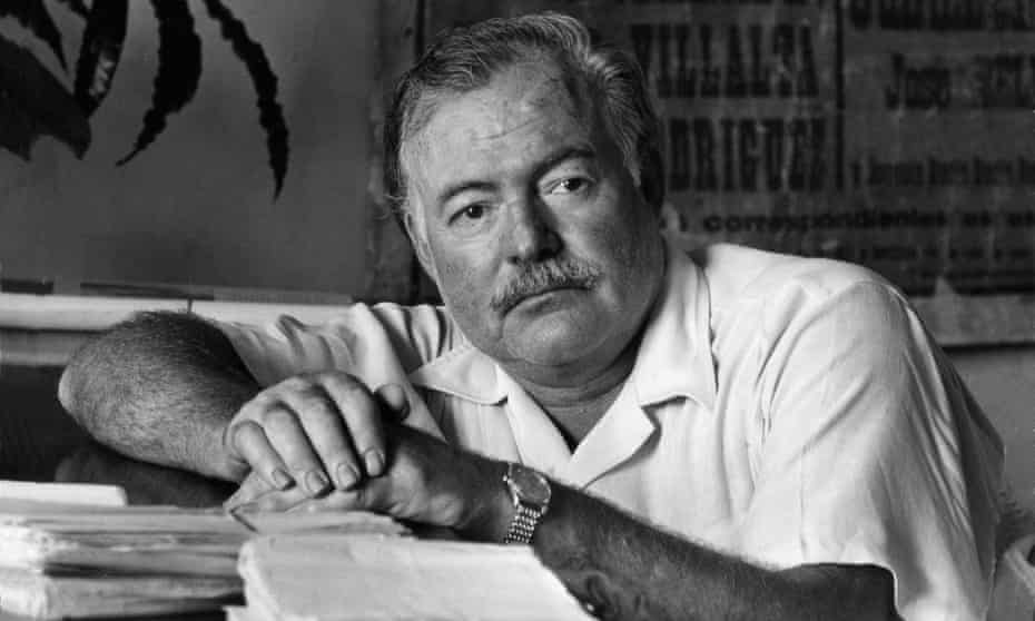 Ernest Hemingway leaning on the desk of his office