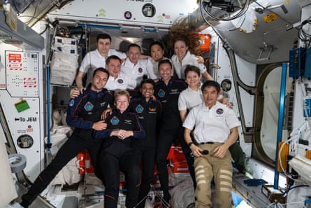 Group photo of astronauts pose for a photo inside the Harmony module of the International Space Station