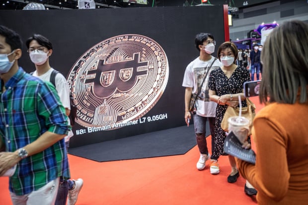Visitors walk past a bitcoin image at Thailand Crypto Expo 2022 at Bangkok International Trade &amp; Exhibition Centre (BITEC) on May 14, 2022