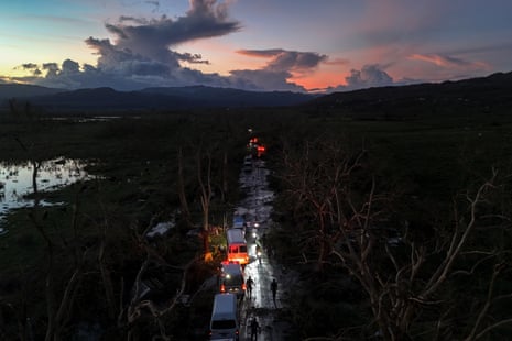A convoy carrying aid to Black River, makes its way through Holland Bamboo, Jamaica, where downed trees and debris partially block the road.