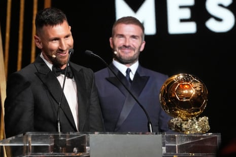 Inter Miami team co-owner and former soccer star David Beckham (right) smiles as Inter Miami's and Argentina's national team player Lionel Messi receives the 2023 Ballon d'Or trophy.