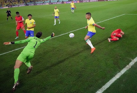 Brazil's keeper Alisson claws the ball away as Thiago Silva looks on.