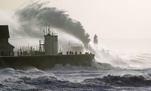 Waves crash against the sea wall and Porthcawl Lighthouse in Bridgend, Wales. Photo: Jacob King/PA Wire
