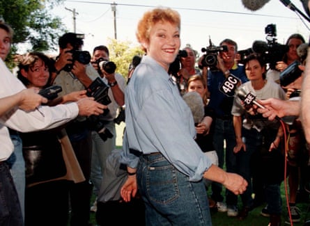 A smiling Hanson in front of a press pack