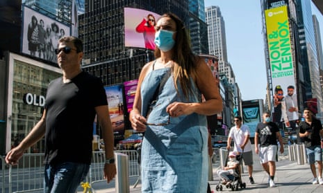 People wear masks around Times Square, as cases of the infectious coronavirus Delta variant continue to rise in New York City.