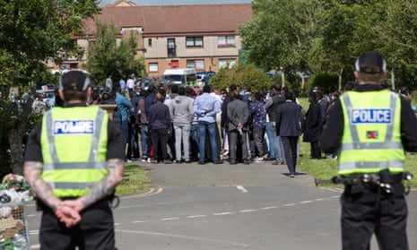 Police stand guard during the funeral of Badreddin Abedlla Adam in Glasgow