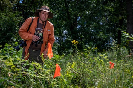 A man with a sun hat looks forward in a wilderness