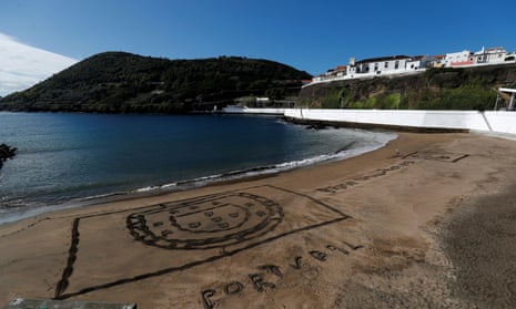 Portugal's coat of arms is seen carved in sand on a beach in Angra do Heroismo on the Azores islands in 2019.