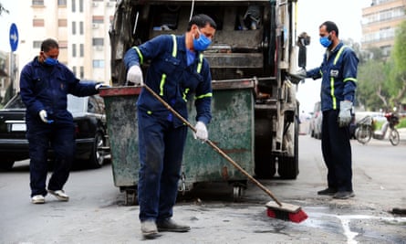 Workers clean a street in Damascus