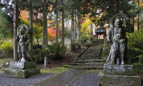 Two fearsome stone figures at the foot of tree-lined stone stairs leading up to the Futago-ji temple