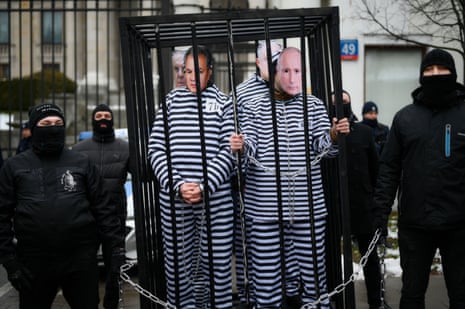 Four men dressed in prison overalls with masks of the faces of Vladimir Putin, Russian minister of defence Sergei Shoigu, Russian minister of foreign affairs Sergei Lavrov and Belarusian president Aleksander Lukashenko.