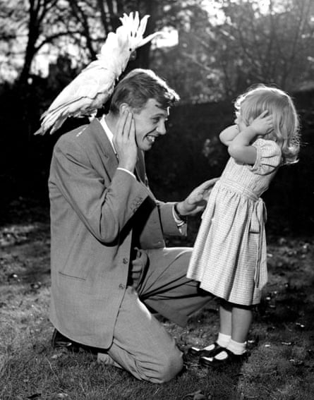 3 year old Susan and her father David Attenborough cover their ears as sulphur crested cockatoo Georgie (sitting on his shoulder) lets out a piercing shriek. 7th December 1957.