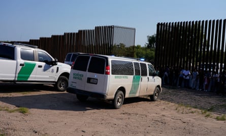 Border Patrol vehicles seen by the border wall in Eagle Pass, Texas.