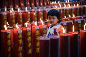 A girl is seen among candles at a temple in Bogor, West Java, Indonesia.