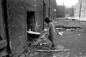 Glasgow, 1970. A mother takes her baby inside her condemned tenement block in the Gorbals