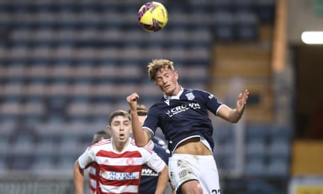 Ben Williamson of Dundee heads clear from Andy Winter of Hamilton Academical during a match in the  Scottish Championship