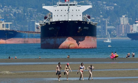 People cool off at a beach in Vancouver as a record heatwave hits western Canada.