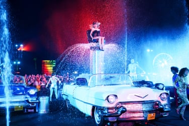 Sabrina Carpenter sits on a high car seat that is also a fountain on stage at Coachella