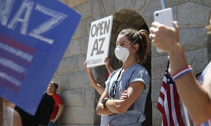 A healthcare worker stands in counter-protest to the “Re-open Arizona” rally around her.