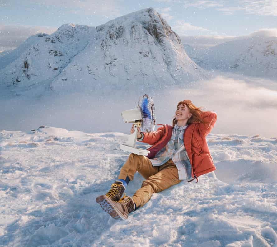 Woman holding fan whilst sitting in the snow.