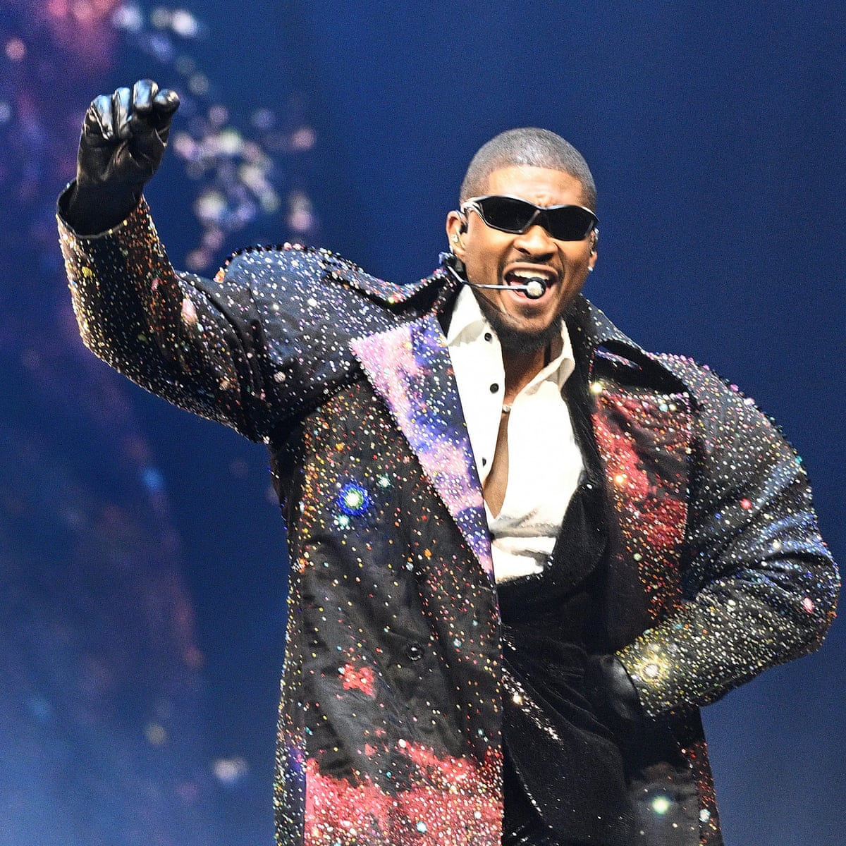 Usher captivates the crowd with his charismatic stage presence, embodying the theatrical flair of modern pop performances.