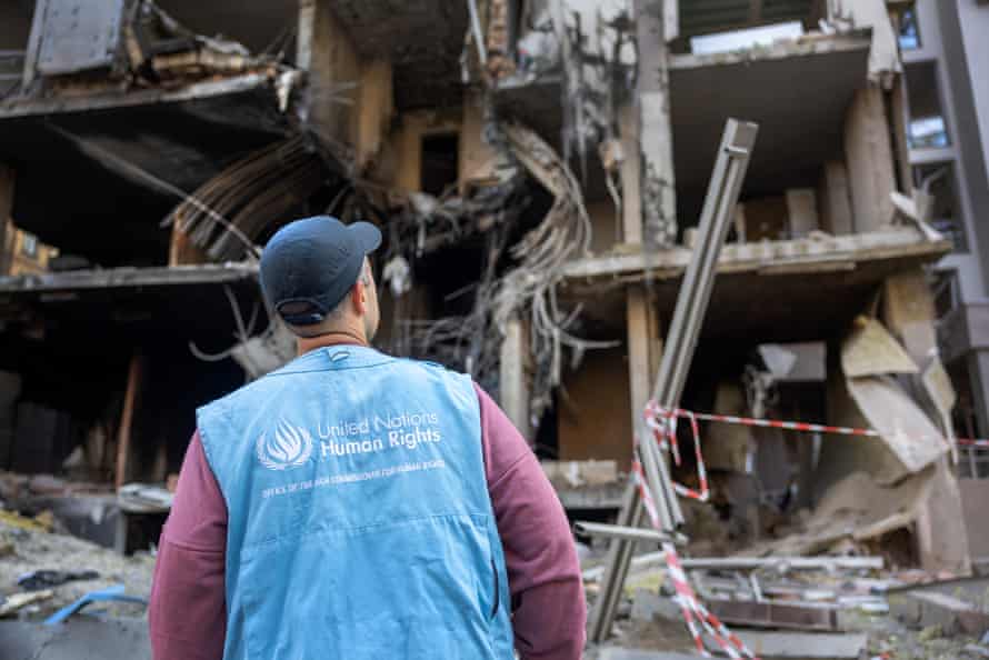 A United Nations human rights monitor looks over damage the morning after the missile strike.