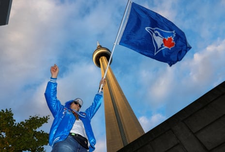 A supporter of the Blue Jays waves a flag with the CN Tower in the background before Saturday’s game.